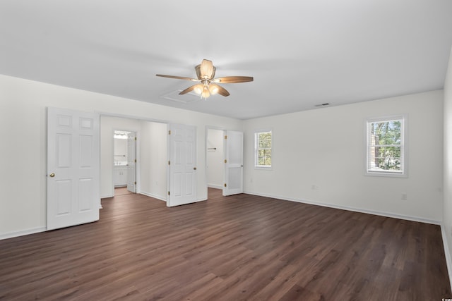 unfurnished bedroom featuring a ceiling fan, dark wood-style flooring, visible vents, and baseboards