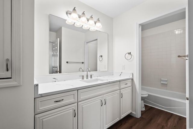 bathroom with bathing tub / shower combination, wood finished floors, vanity, and toilet