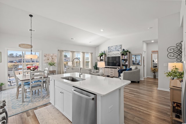 kitchen featuring lofted ceiling, visible vents, stainless steel dishwasher, a sink, and wood finished floors