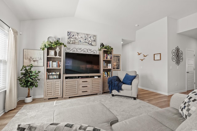 living room with baseboards, vaulted ceiling, and wood finished floors