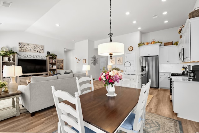 dining space featuring lofted ceiling, recessed lighting, visible vents, and light wood-style flooring