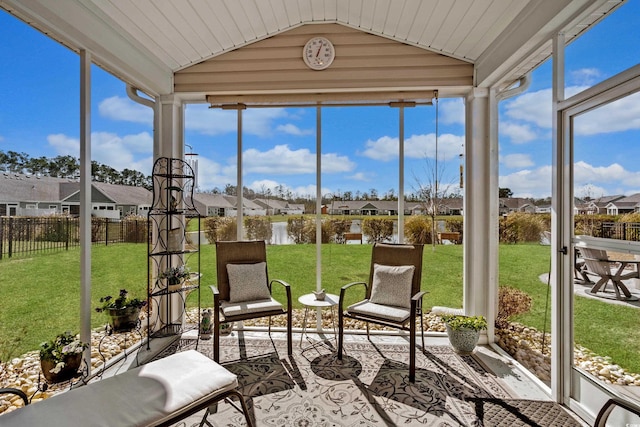 sunroom featuring a residential view and vaulted ceiling