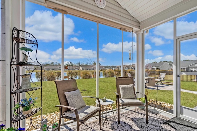 sunroom with lofted ceiling and a residential view