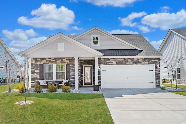 view of front facade featuring driveway, a front lawn, an attached garage, and stone siding