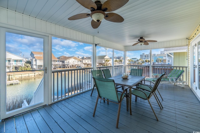 sunroom / solarium with a residential view, a water view, and plenty of natural light