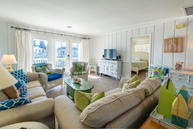 living room with visible vents, wood finished floors, and french doors