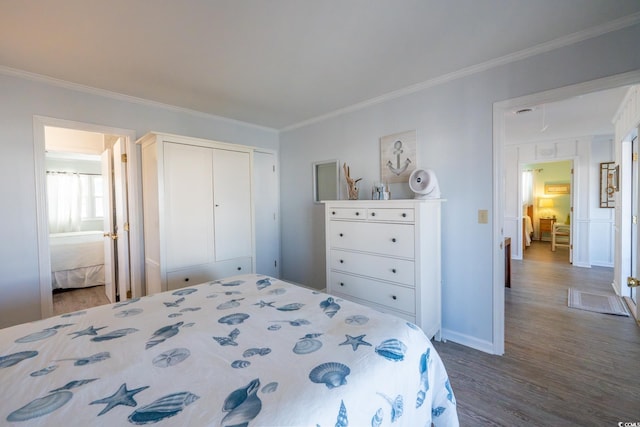 bedroom with baseboards, wood finished floors, attic access, and crown molding