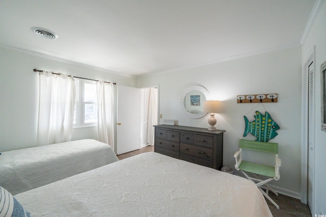 bedroom with light wood-style flooring, visible vents, and crown molding