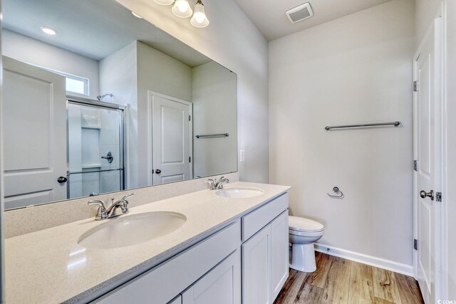 491 Wagner Cir, Conway, SC 29526 - bathroom with double vanity, wood finished floors, a shower with door, baseboards, and toilet