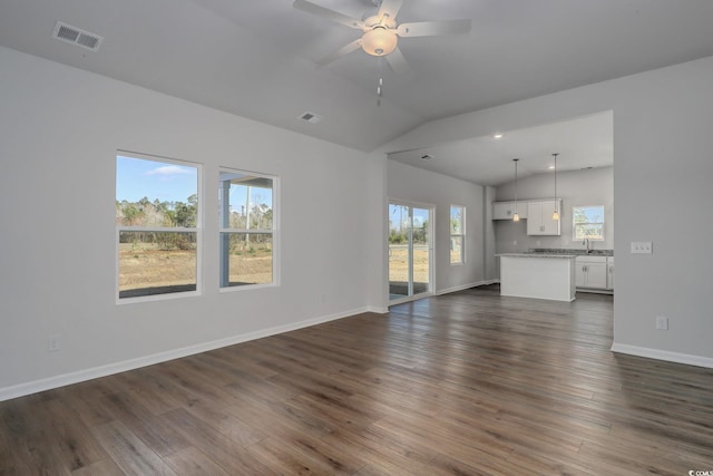 unfurnished living room with dark wood-style floors, visible vents, vaulted ceiling, and a sink