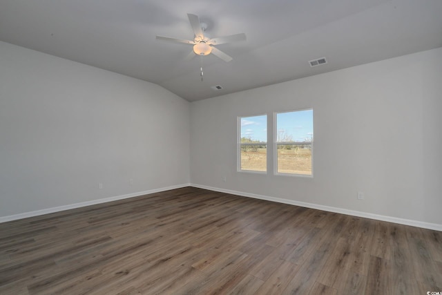 empty room featuring dark wood-type flooring, visible vents, ceiling fan, and baseboards