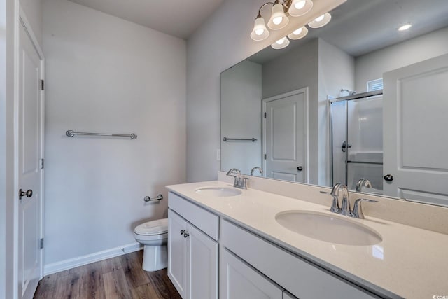 full bath featuring wood finished floors, a sink, toilet, and a shower stall