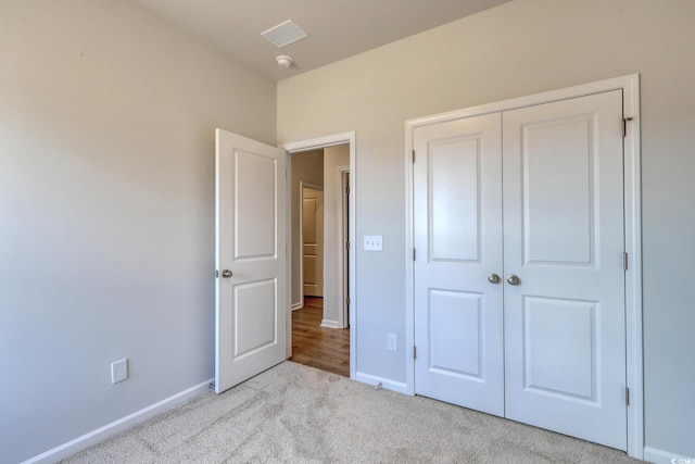 unfurnished bedroom featuring carpet, a closet, visible vents, and baseboards