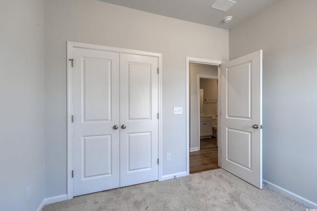 unfurnished bedroom with carpet floors, baseboards, visible vents, and a closet