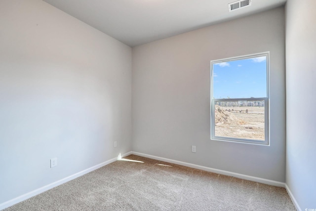 carpeted empty room with visible vents and baseboards