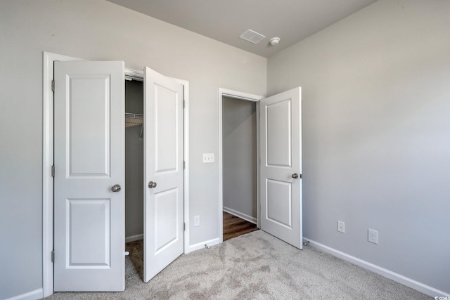 unfurnished bedroom featuring a closet, carpet, visible vents, and baseboards