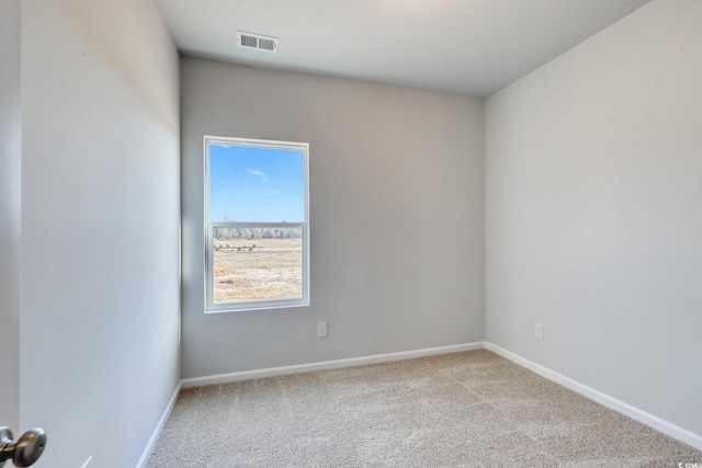 empty room with baseboards, visible vents, and carpet flooring