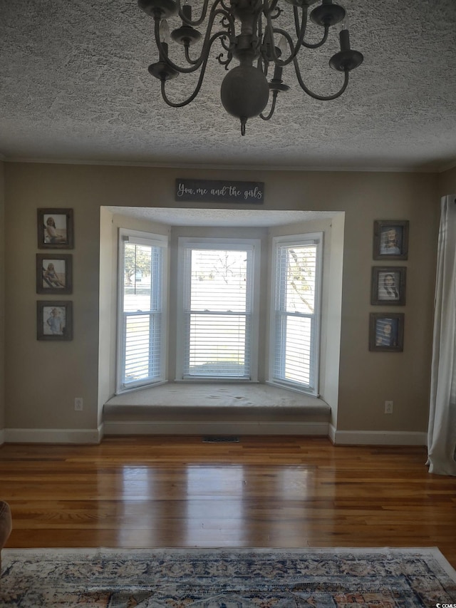 interior space featuring a textured ceiling, plenty of natural light, and wood finished floors