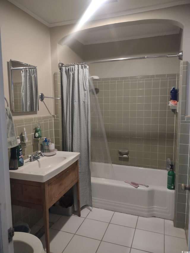 bathroom featuring tile walls, shower / bathtub combination with curtain, ornamental molding, vanity, and tile patterned flooring