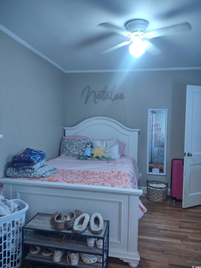 bedroom with ceiling fan, wood finished floors, and crown molding