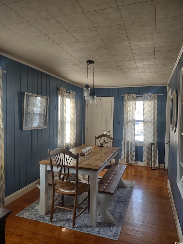 dining area with baseboards, wood finished floors, and a healthy amount of sunlight