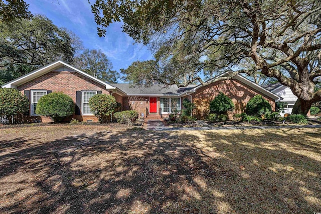 ranch-style home featuring a front lawn and brick siding