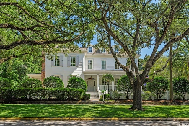 view of front of house with a porch and a front yard