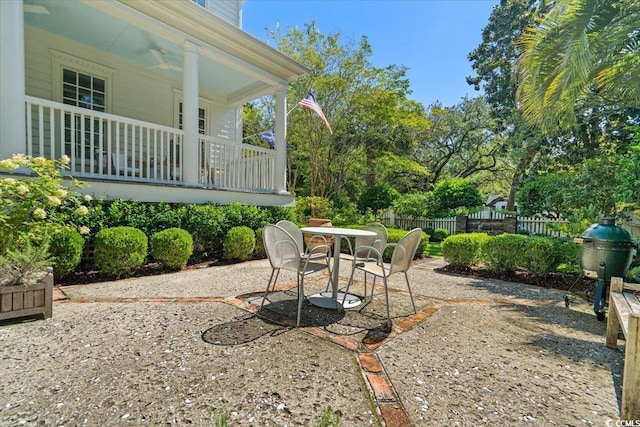 view of yard with covered porch, fence, and a patio