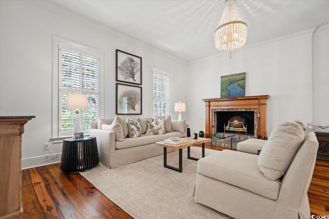 living room featuring baseboards, ornamental molding, wood-type flooring, and an inviting chandelier