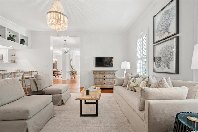 living room featuring wood finished floors, crown molding, and an inviting chandelier