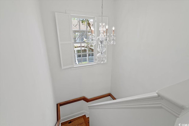 staircase with a notable chandelier