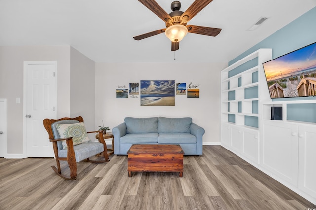 living area with ceiling fan, visible vents, baseboards, and wood finished floors