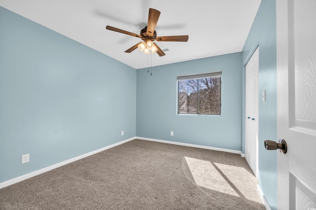 carpeted spare room with baseboards and a ceiling fan