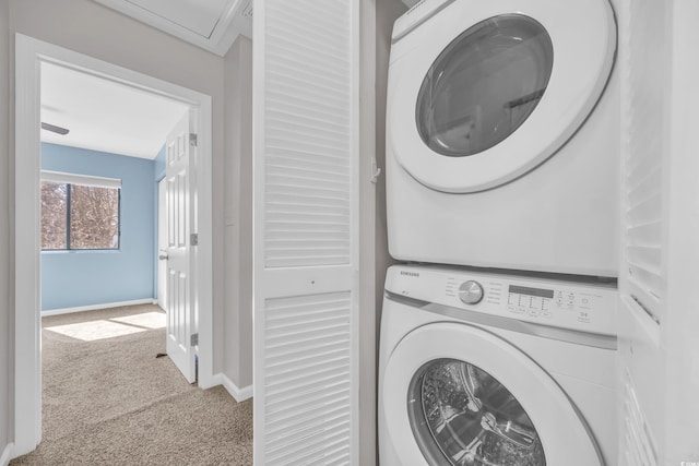 laundry area with laundry area, stacked washer / drying machine, baseboards, and carpet floors