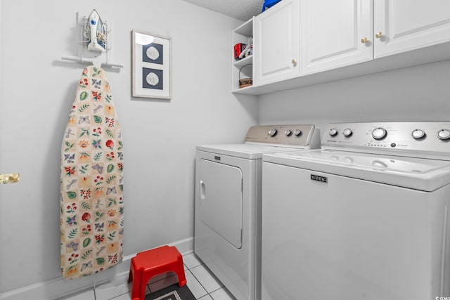 washroom with cabinet space, tile patterned floors, baseboards, and washing machine and clothes dryer