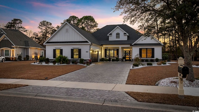 view of front of property featuring a standing seam roof, metal roof, decorative driveway, and board and batten siding