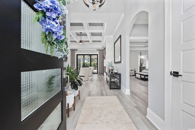 foyer with arched walkways, wood finished floors, coffered ceiling, beamed ceiling, and baseboards