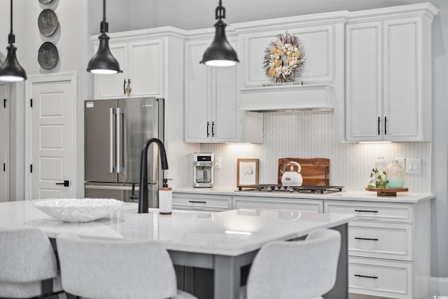 kitchen featuring a breakfast bar, custom exhaust hood, stainless steel appliances, and backsplash