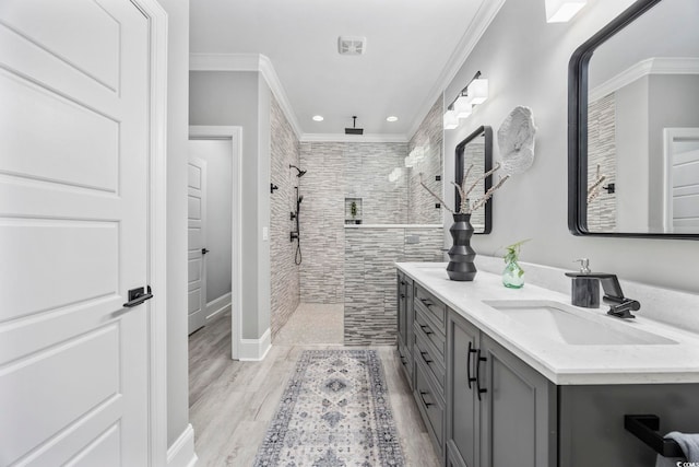 bathroom featuring crown molding, double vanity, a sink, and walk in shower