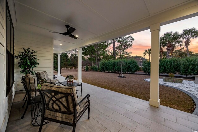 patio terrace at dusk featuring ceiling fan