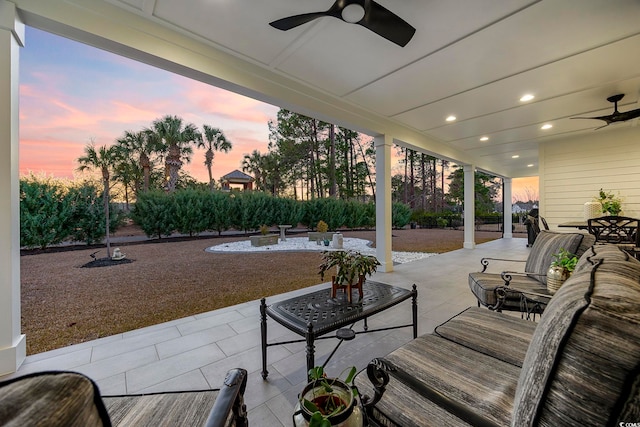 patio terrace at dusk with an outdoor hangout area and a ceiling fan