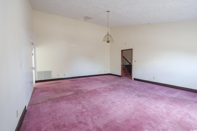 carpeted spare room with a textured ceiling, high vaulted ceiling, visible vents, baseboards, and stairs