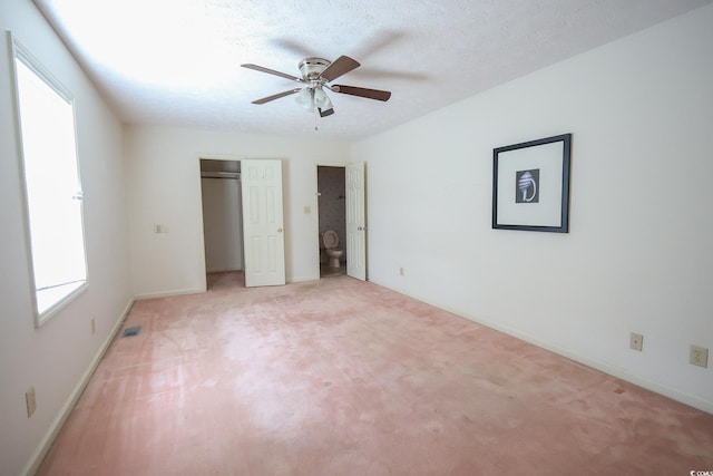 unfurnished bedroom featuring a textured ceiling, light carpet, a ceiling fan, baseboards, and a closet