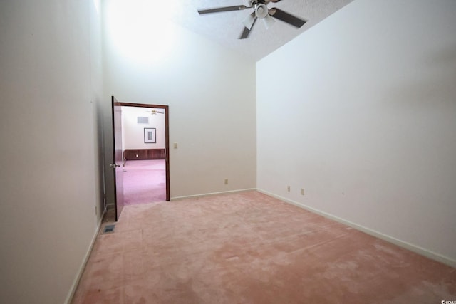 unfurnished room featuring light carpet, high vaulted ceiling, a ceiling fan, and baseboards