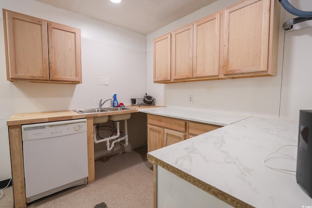 kitchen with light floors, light brown cabinets, white dishwasher, and a sink