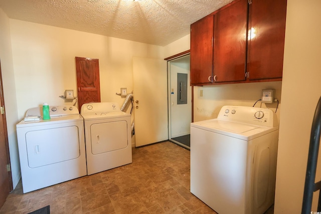 laundry area featuring a textured ceiling, independent washer and dryer, cabinet space, and electric panel