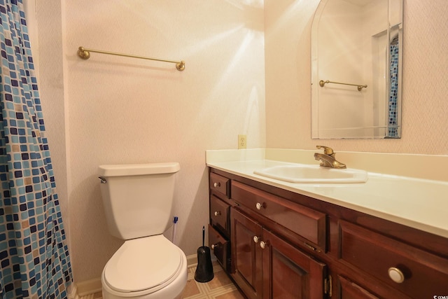 bathroom featuring toilet, curtained shower, baseboards, and vanity