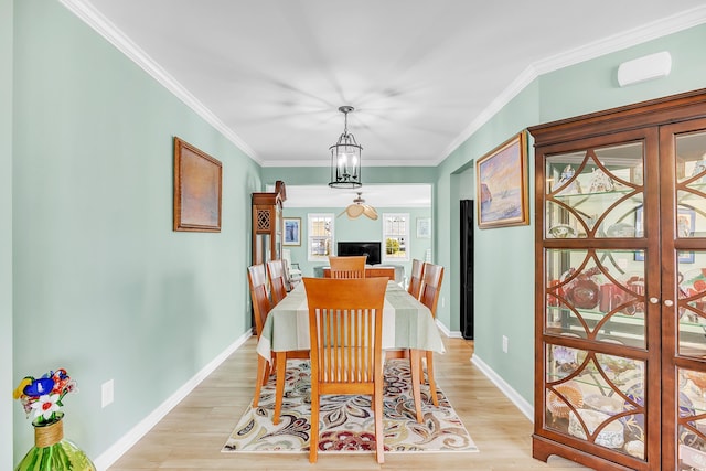 dining room with light wood-type flooring, french doors, and crown molding