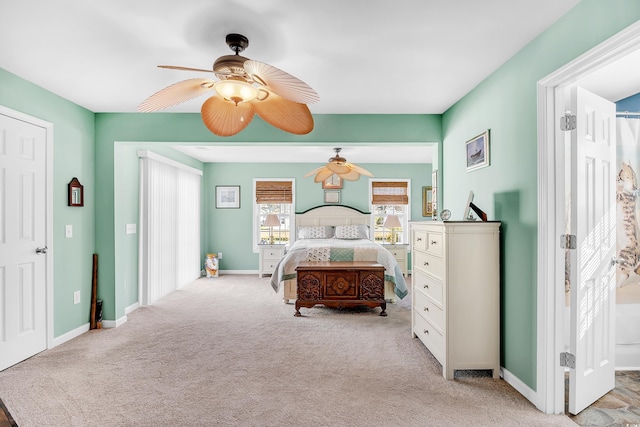 bedroom featuring a ceiling fan, light colored carpet, and baseboards