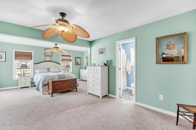 bedroom featuring ensuite bath, carpet flooring, a ceiling fan, and baseboards